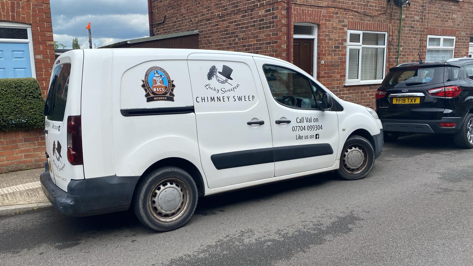 White Lucky Sweepess chimney sweep van parked on a street in York